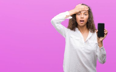 Baş, el ile vurguladı smartphone kullanan genç İspanyol kadın şok utanç ve sürpriz suratla, öfkeli ve sinirli. Korku ve hata için üzgün.