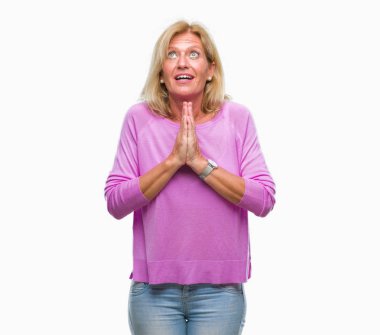 Orta yaş sarışın kadın dilencilik ve umut ifade yüzünde çok duygusal ve endişe ile birlikte elleriyle dua izole arka plan yüzünden. Bağışlanmak. Din kavramı.