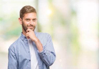 Emin çapraz kollar ve çeneme kaldırdı el ile gülümseme ile kameraya bakarak izole arka plan üzerinde beyaz t-shirt giyen genç yakışıklı adam. Pozitif düşünce.