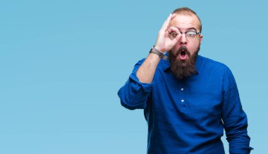 Sürpriz yüz, göz parmaklarının arasından seyir ile ok jest yapıyor izole arka plan üzerinde gözlüklü Genç beyaz hipster adam şok. İmansız ifade.