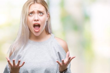 Sarışın genç kadın izole arka plan çılgın ve kızgın bağırarak ve agresif ifade ve silah kaldırdı bağırıyor. Hayal kırıklığı kavramı.