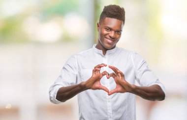 Afrikalı-Amerikalı genç aşık kalp simgesi ve elleriyle şekil gösteren gülümseyen izole arka plan üzerinde. Romantik kavramı.