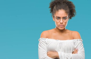 İzole arka plan şüpheci ve çapraz kolları olan yüzündeki gergin, onaylamayan ifade gözlüklü genç afro Amerikalı kadın. Negatif kişi.