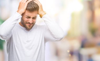 Yakışıklı delikanlı çünkü umutsuz ve stresli baş ağrısı acı izole arka plan üzerinde ağrı ve migren. Ellerini kafasına.