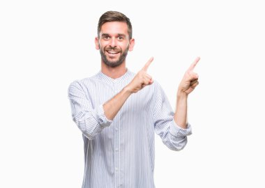 Yakışıklı delikanlı gülümseyen ve iki elleri ve parmakları ile tarafına işaret kamera bakarak izole arka plan üzerinde.