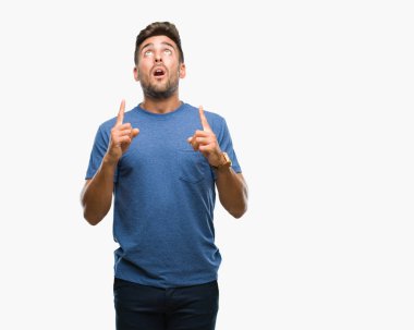 Yakışıklı delikanlı izole arka plan üzerinden hayran ve yukarıya bakıp parmakları ile işaret şaşırttı ve silah kaldırdı.