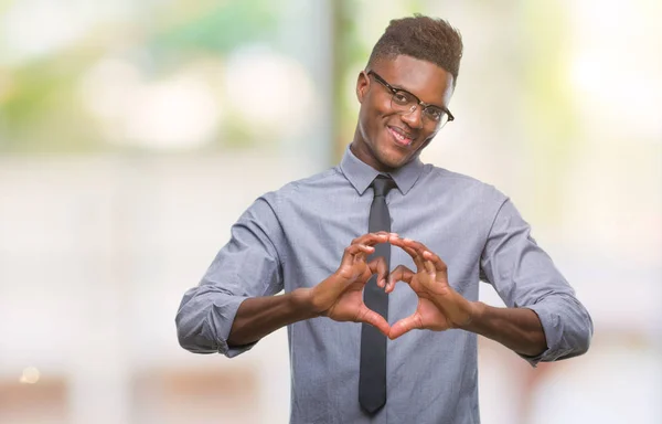 Young african american business man over isolated background smiling in love showing heart symbol and shape with hands. Romantic concept.