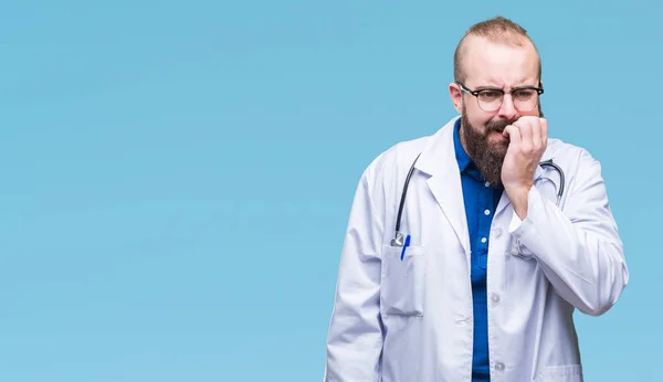 不安や両手の爪を噛んで口の中で緊張を探して孤立の背景の上医療白衣を着た若い白人医師男 不安の問題 — ストック写真
