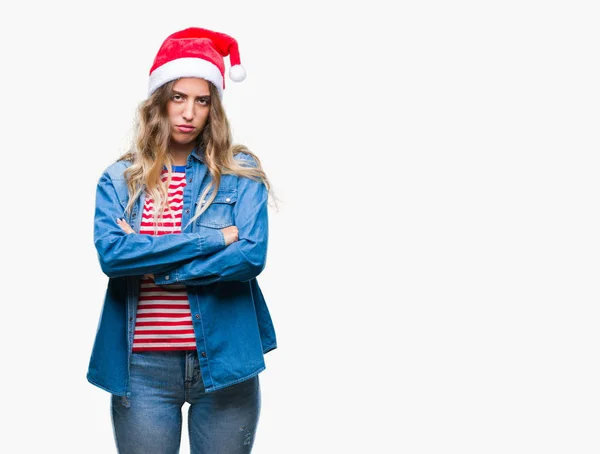 美しい若い金髪女性の孤立した背景の懐疑論者と組んだ腕で顔の神経 不賛成式クリスマス帽子をかぶっています 否定的な人 — ストック写真