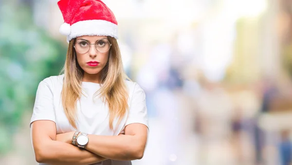 年轻的美丽的女人戴着圣诞帽在孤立的背景怀疑和紧张 不赞成的表情在脸上交叉的手臂 消极的人 — 图库照片
