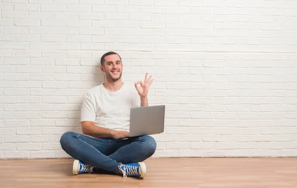 Giovane Uomo Caucasico Seduto Sopra Muro Mattoni Bianchi Utilizzando Computer — Foto Stock