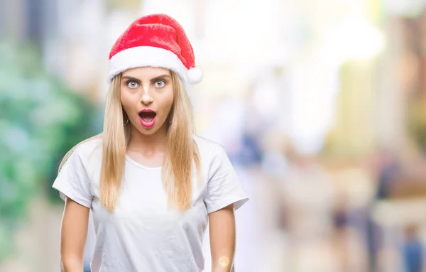 年轻美丽的金发碧眼的女人圣诞帽在孤立的背景恐惧和震惊与惊奇的表情 恐惧和兴奋的面孔 — 图库照片