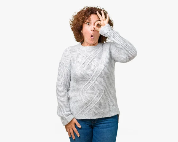 のジェスチャーを行う分離の背景に冬のセーターを着て美しい中間エイガー年配の女性は 驚いた顔で 指を通して見る目ショックを受けた 疑うような式 — ストック写真