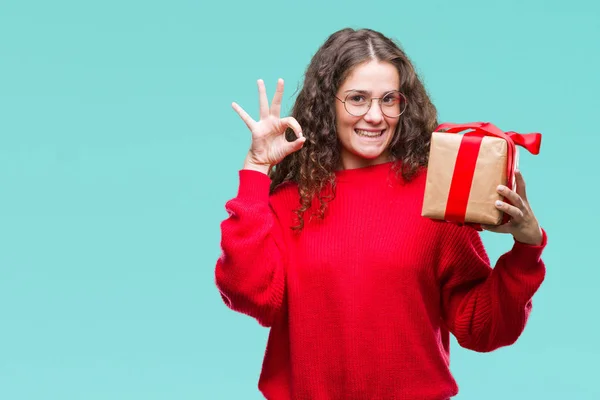 Menina Morena Jovem Segurando Presente Sobre Fundo Isolado Fazendo Sinal — Fotografia de Stock