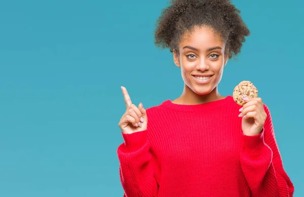 Junge Afroamerikanerin Isst Schokoladenkeks Über Isoliertem Hintergrund Überrascht Mit Einer — Stockfoto