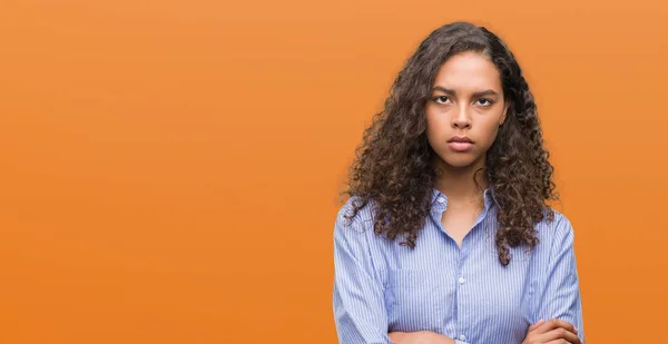 Young hispanic business woman skeptic and nervous, disapproving expression on face with crossed arms. Negative person.