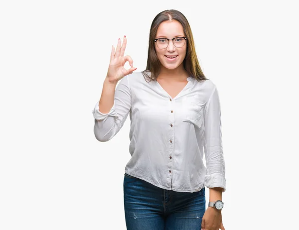 年轻的高加索美丽的女商人戴眼镜在孤立的背景微笑积极做确定的迹象与手和手指 成功的表达 — 图库照片