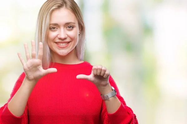 Young blonde woman wearing winter sweater over isolated background showing and pointing up with fingers number six while smiling confident and happy.