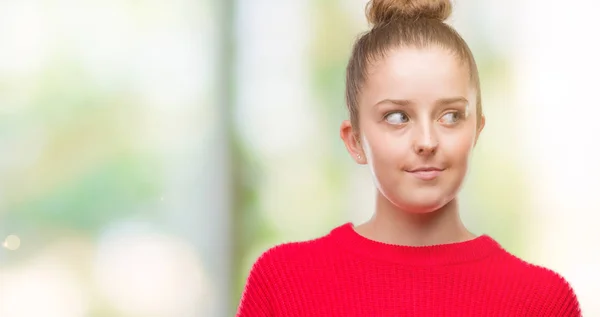 Joven Mujer Rubia Vistiendo Moño Suéter Rojo Sonriendo Mirando Lado —  Fotos de Stock