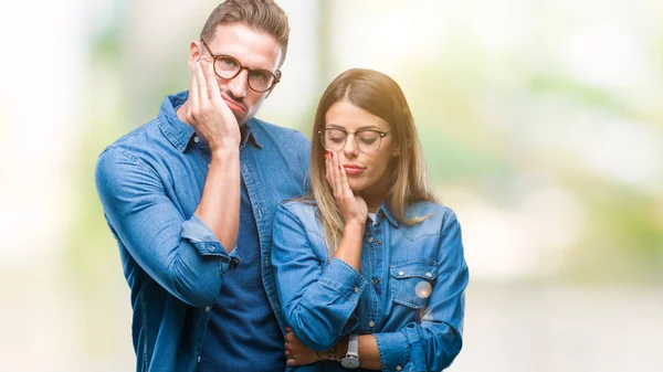 年轻夫妇在爱戴眼镜在孤立的背景思维看累了 无聊与交叉胳膊抑郁症问题 — 图库照片