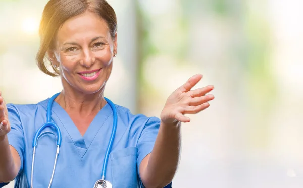 中年资深护士医生在与世隔绝的背景下看着相机微笑着张开双臂拥抱 快乐的表达拥抱幸福 — 图库照片