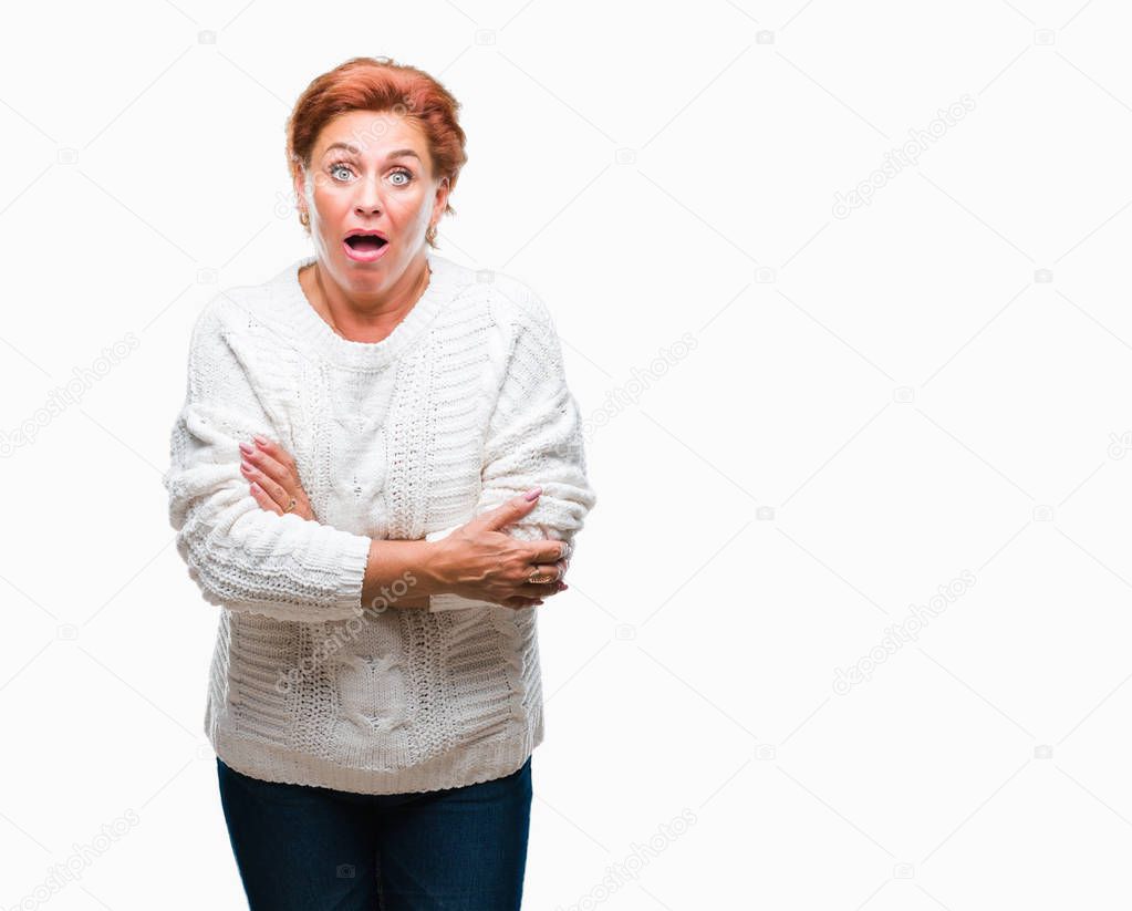 Atrractive senior caucasian redhead woman wearing winter sweater over isolated background afraid and shocked with surprise expression, fear and excited face.