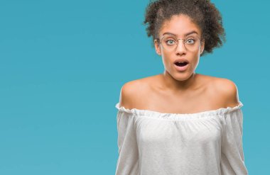 Korkuyor ve şok sürpriz ifade, korku ve heyecan yüz ile izole arka plan üzerinde gözlük takan genç afro Amerikalı kadın.