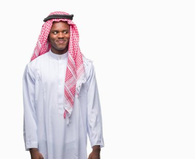 Geleneksel keffiyeh görünümlü yan ve dik dik bakma uzağa düşünce gülümseyen izole arka plan üzerinde giyen genç Arapça Afrika adam.