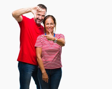 Orta yaş İspanyol çift elle yapma çerçeve ve parmakları ile mutlu yüz gülümseyen izole arka plan üzerinde aşık. Yaratıcılık ve Fotoğrafçılık kavramı.