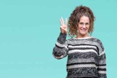 Güzel esmer kıvırcık saçlı Genç kız üzerinde gözlük takan gösterilen arka plan izole ve parmakları ile işaret kendinden emin ve mutlu gülümseyerek iken üçüncü.