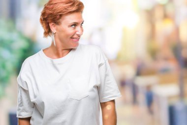 İzole arka plan uzak tarafına gülümseme ile yüzünde, doğal ifade seyir üzerinde üst düzey beyaz Kızıl saçlı kadın Atrractive. Kendine güvenen gülüyor.