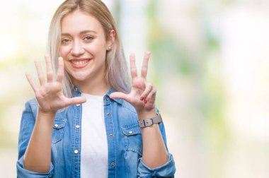 Genç Sarışın kadın gösterilen ve parmakları ile işaret izole arka plan yüzünden kendinden emin ve mutlu gülümseyerek süre 8 numaralı.