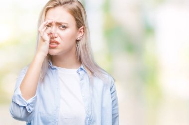 Sarışın genç kadın bir şey pis ve iğrenç kokulu izole arka plan, dayanılmaz koku, holding nefes burun parmaklar ile. Kötü kokuyor kavramı.