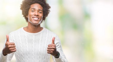 El ile pozitif jest yapıyor izole arka plan başarı işareti üzerinde Afro Amerikalı adam başparmak gülümseyen ve mutlu. Neşeli bir ifadeyle, kazanan jest kameraya bakıyor.