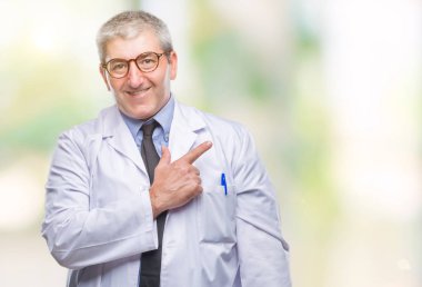 Yakışıklı kıdemli Doktor, üzerinde beyaz önlük giyen bilim adamı profesyonel adam arka plan neşeli bir gülümseme ile el ve parmak kadar mutlu ve doğal ifade kameraya bakarak yüzünde yanında işaret yüz ile izole..