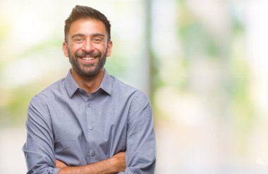 Kameraya bakarak çapraz silah ile gülümseyen izole arka plan mutlu yüz yetişkin İspanyol adam. Olumlu bir kişi.