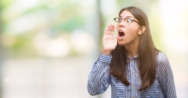 Bağırarak ve ağzı üzerinde el ile yan için çığlık genç güzel İspanyol iş kadını. İletişim kavramı.