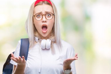 Genç sarışın öğrenci kadın gözlük ve sırt çantası korkuyor ve şok sürpriz ifade ile izole arka plan üzerinde korku ve yüz heyecanlı.