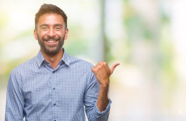 Seyir ve başparmak yanında yukarıyı mutlu yüz ile gülümseyen izole arka plan yetişkin İspanyol adam.