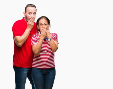 Orta yaş İspanyol çift izole arka plan ağız hata için elleriyle kapsayan şok içinde aşık. Gizli kavramı.