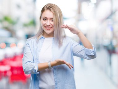 Sarışın genç kadın ile büyük ve büyük boy işaret, ölçü birimi sembol gösteren el eller izole arka plan üzerinde. Kameraya bakarak gülümsüyordu. Ölçüm kavramı.