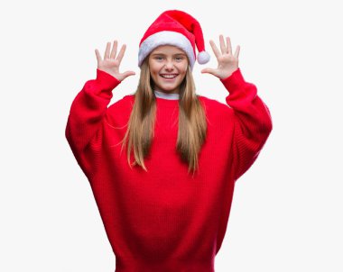 Genç güzel kız giyen Noel şapka gösterilen ve parmakları ile işaret izole arka plan üzerinde kendinden emin ve mutlu gülümseyerek süre on numara.