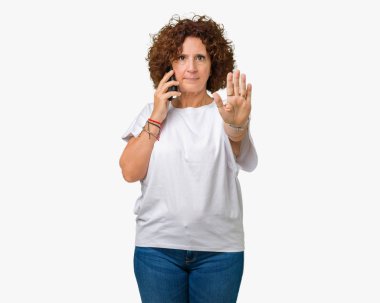 Orta ager üst düzey kadın Smartphone'da açık eliyle dur işareti ile ciddi ve kendine güvenen ifade, savunma jest yapıyor izole arka plan üzerinde söz