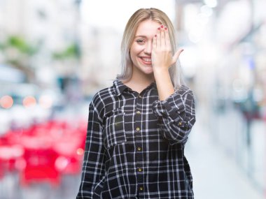 Sarışın genç kadın el yüz ve sürpriz duygu kendinden emin gülümseme ile tek gözüyle kapsayan izole arka plan üzerinde.