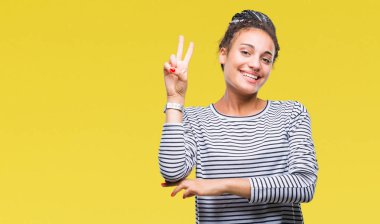 Genç örgülü saç Afro-Amerikan kız mutlu yüz zafer işareti yaparken kameraya göz kırpıyor ile gülümseyen izole arka plan üzerinde kazak giyiyor. İki numaralı.