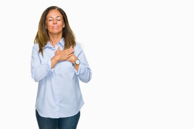 Eller güzel orta yaş iş yetişkin kadın ile gülümseyen izole arka plan üzerinde kapalı gözler ve yüzünde minnettar jest ile göğüs üzerinde. Sağlık kavramı.