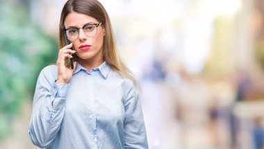 Acımak yüz ciddi düşünüyorum üstünde kendine güvenen bir ifade ile arka plan üzerinde Smartphone kullanarak arama konuşan genç güzel iş kadını izole