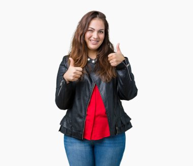 Artı boyutu genç kadın güzel izole arka plan başarı işareti el ile pozitif jest yapıyor üzerinde bir moda deri ceket giyiyor başparmak gülümseyen ve mutlu. Neşeli bir ifadeyle, kazanan jest kameraya bakıyor.