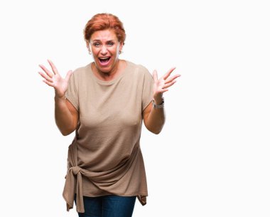 Atrractive üst düzey beyaz Kızıl saçlı kadın deli kutluyor arka plan izole ve başarı için kaldırdı kollarını açarak hayrete ve heyecanlı çığlık gözleri açık. Kazanan kavramı