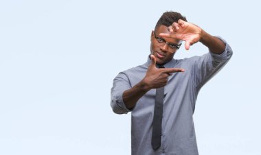 Elle yapma çerçeve ve parmakları ile mutlu yüz gülümseyen izole arka plan üzerinde genç Afro-Amerikalı iş adamı. Yaratıcılık ve Fotoğrafçılık kavramı.
